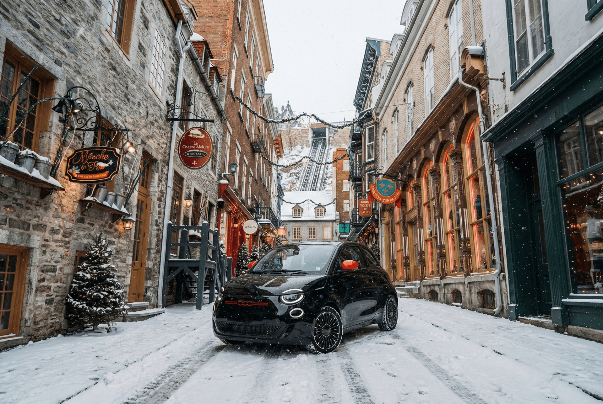 Fiat 500e circulant facilement dans une rue étroite enneigée du Vieux-Québec, démontrant sa manœuvrabilité en hiver