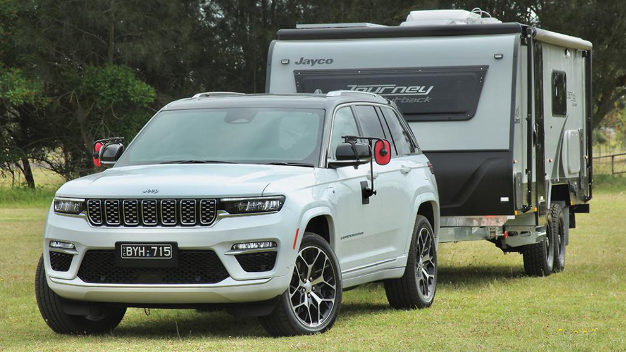 vue latérale avant d'un Jeep Grand Cherokee 4xe 2025 remorquant une roulotte