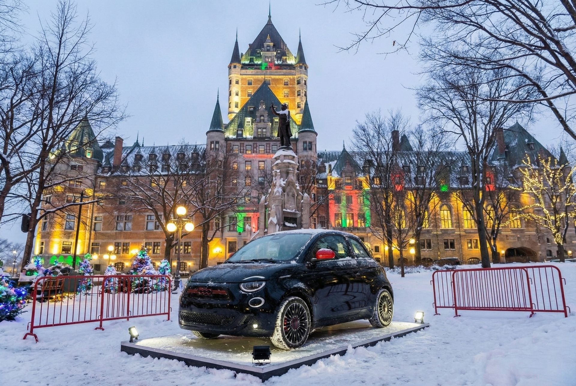 Fiat 500e exposée en hiver devant le Château Frontenac illuminé, au cœur de la ville de Québec décorée pour Noël.