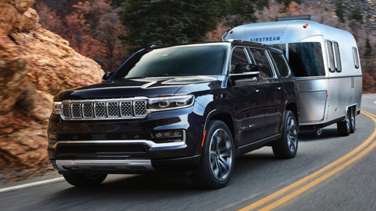 vue latérale avant d'un Jeep Grand Wagoneer 2025 qui remorque une roulotte