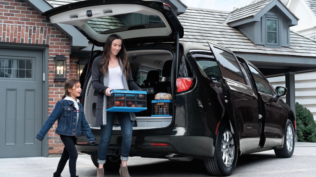 vue d'une famille en train de charger l'arrière d'une Chrysler Grand Caravan 2025