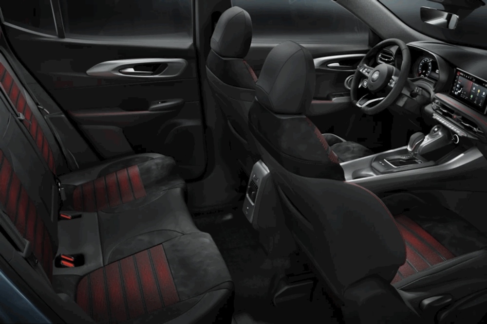 Habitacle du Dodge Hornet 2025 vu depuis l’arrière, avec sièges sport en suède noir et accents rouges.