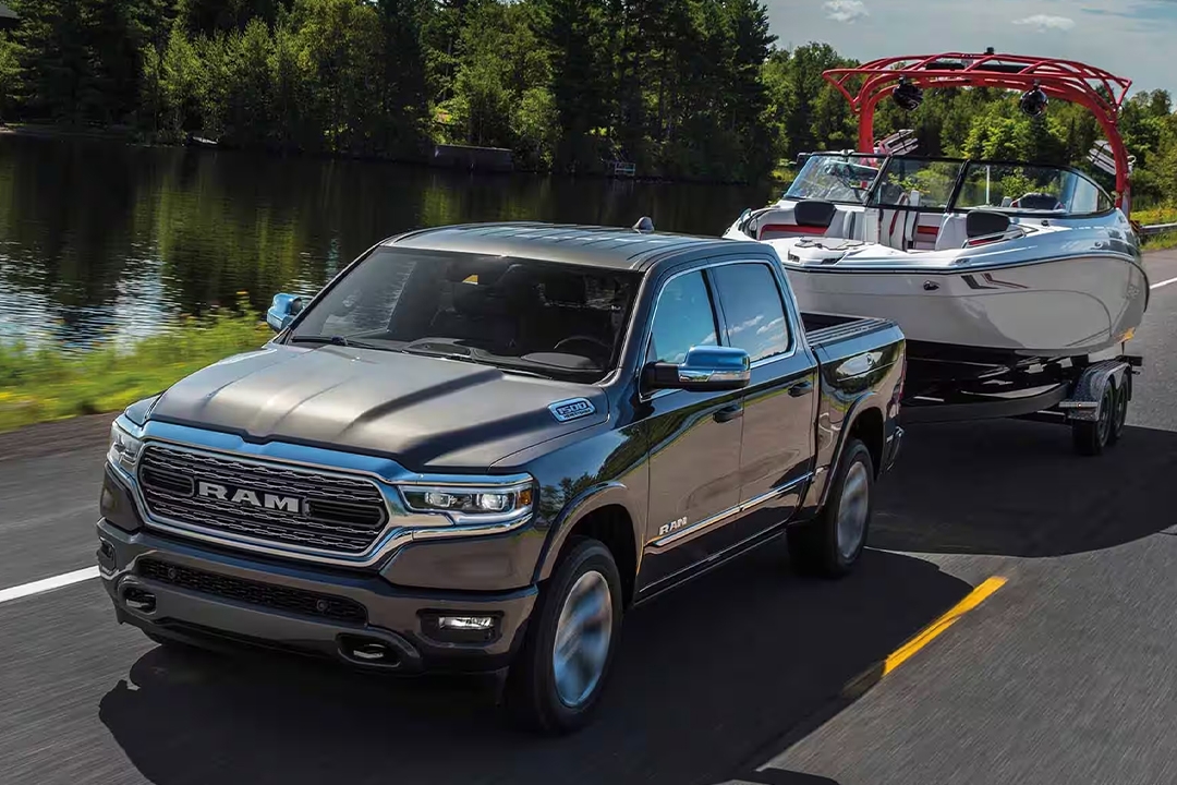 Vue 3/4 avant du RAM 1500 remorquant un bateau sur une route.