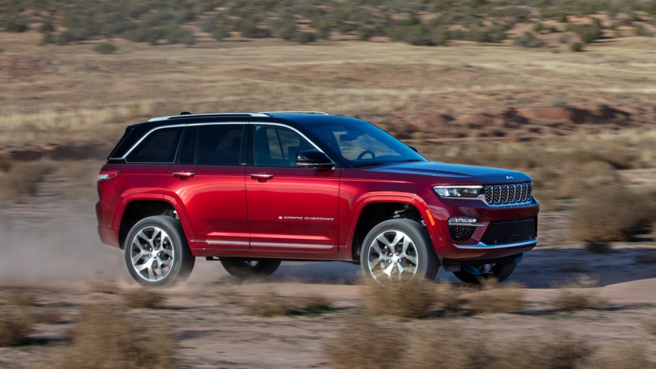vue latérale avant d'un Jeep Grand Cherokee 2025 sur une route dans le désert