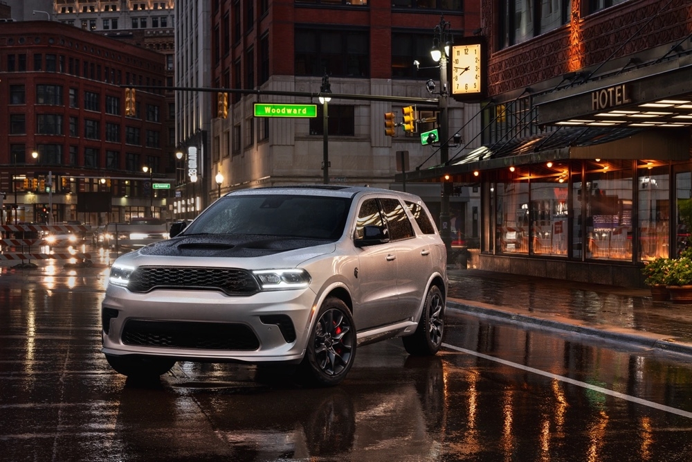 Dodge Durango SRT Hellcat 2025 argenté stationné de nuit dans une rue animée du centre-ville.