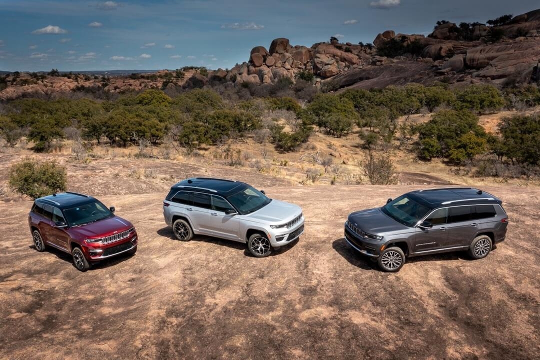 Trois Jeep Grand Cherokee stationnés sur le terre.